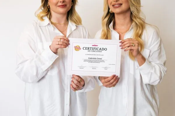 As Inaás segurando o certificado de conclusão Unitec/MEC
