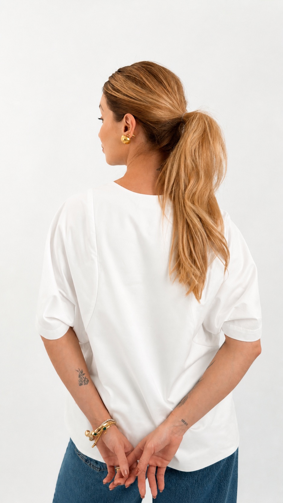 Blusa Vênus em tricoline branca vista de costas, mostrando o caimento solto e a fluidez do corte